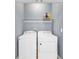 Bright laundry room featuring a white washer, dryer, and storage shelf for supplies at 3012 Keeneland Blvd, Mcdonough, GA 30252