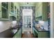 Stylish butler's pantry with green cabinetry, dark countertops, and wallpaper accents at 785 Wilson Nw Rd, Atlanta, GA 30318