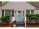 Charming front door with light-blue paint and decorative sidelights, framed by landscaped bushes and dark-painted porch at 2599 E Tupelo Se St, Atlanta, GA 30317