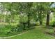 Lush backyard with mature trees, green grass and a brick paver walking path at 2736 Whisper Trl, Douglasville, GA 30135