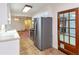 View of kitchen with stainless steel refrigerator and tile floor leading to living area at 2736 Whisper Trl, Douglasville, GA 30135