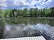 Calm lake view showcasing reflections of the sky and surrounding trees at 2736 Whisper Trl, Douglasville, GA 30135