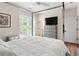 Bright bedroom includes silver canopy bed frame, side table, TV and hard wood flooring at 3484 Orchard St, Atlanta, GA 30354