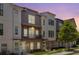 Townhome with brick facade, gray siding, balcony, and manicured lawn, bathed in the warm hues of the evening sky at 3484 Orchard St, Atlanta, GA 30354