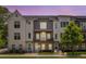 Townhome with brick facade, gray siding, balcony, and manicured lawn, bathed in the warm hues of the evening sky at 3484 Orchard St, Atlanta, GA 30354