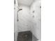Bright shower includes white marble tiling, black herringbone floor and glass door at 3484 Orchard St, Atlanta, GA 30354