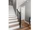 Stylish staircase featuring hardwood floors, white risers, and a sleek black railing at 3484 Orchard St, Atlanta, GA 30354