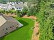 Overhead shot of a lush green backyard showcasing a well maintained lawn with trees, flowers, and a small patio at 3962 Roberts Crest Dr, Suwanee, GA 30024