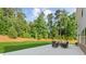 Backyard featuring an expansive lawn, mature trees, and an outdoor seating area at 3962 Roberts Crest Dr, Suwanee, GA 30024