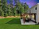 Backyard patio with a dining table underneath a pergola with outdoor lighting, perfect for outdoor gatherings at 3962 Roberts Crest Dr, Suwanee, GA 30024