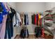 Walk-in closet features metal racks with hanging clothes on shelves for storage at 3962 Roberts Crest Dr, Suwanee, GA 30024