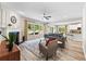 Bright living room with a fireplace, large windows, wood floors, and open to kitchen area at 3962 Roberts Crest Dr, Suwanee, GA 30024