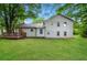Backyard view of a two-story home featuring a wooden deck and spacious lawn surrounded by mature trees at 6194 Golden Meadow Court Ct, Riverdale, GA 30296