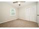 Neutral bedroom with carpet, a ceiling fan, a window, and a closet at 6194 Golden Meadow Court Ct, Riverdale, GA 30296