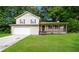 Charming two-story home featuring a covered porch, attached garage, and a well-maintained lawn with green trees at 6194 Golden Meadow Court Ct, Riverdale, GA 30296