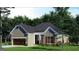 Cozy traditional home with stone accents, an arched front door and a two-car garage at 1077 Crooked Creek Rd, Lithonia, GA 30058