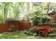 Home featuring a well-maintained yard with a wooden fence, mature trees and colorful landscaping at 1438 Salem Dr, Alpharetta, GA 30009