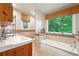 Bright bathroom with a soaking tub, tiled walls, and a window overlooking the backyard at 1438 Salem Dr, Alpharetta, GA 30009