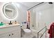 Bright bathroom with white fixtures, a round mirror, a shower-tub combination and floral curtains at 1438 Salem Dr, Alpharetta, GA 30009