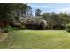 Expansive backyard lawn with flowering trees, and lush landscaping at 1656 N Pelham Ne Rd, Atlanta, GA 30324