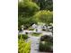Landscaped backyard retreat with stone pathways, lush greenery, and inviting seating areas at 1656 N Pelham Ne Rd, Atlanta, GA 30324
