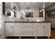 Elegant bathroom showcasing double sinks, white subway tile, a dark countertop, and a view into the closet at 1656 N Pelham Ne Rd, Atlanta, GA 30324