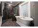 Luxurious bathroom with a freestanding tub, modern shower, and eye-catching tile, lit by a glass block window at 1656 N Pelham Ne Rd, Atlanta, GA 30324