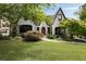 Charming home featuring a manicured lawn, mature trees, and a stone pathway leading to the front door at 1656 N Pelham Ne Rd, Atlanta, GA 30324