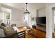 Bright living room featuring hardwood floors, a modern light fixture, and a comfortable daybed with decorative pillows at 1656 N Pelham Ne Rd, Atlanta, GA 30324