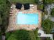 Aerial view of a sparkling pool surrounded by a stone patio, lush greenery, and lounge chairs at 1656 N Pelham Ne Rd, Atlanta, GA 30324