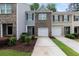 Charming townhome featuring a one-car garage, a well-maintained lawn, and a beautifully designed brick facade at 3155 Tarian Way, Decatur, GA 30034