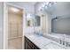 This bright bathroom includes a double vanity, granite countertops, and a large mirror reflecting a walk-in closet at 563 Trillum Sw Ct # 563, Marietta, GA 30008