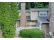 Charming townhouse with brick accents, a white picket fence, and lush greenery enhancing its curb appeal at 563 Trillum Sw Ct # 563, Marietta, GA 30008
