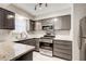 Updated kitchen with stainless steel appliances, granite countertops, and gray cabinets at 563 Trillum Sw Ct # 563, Marietta, GA 30008