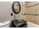Modern bathroom features glass vessel sink, updated fixtures, and tiled shower and bath at 8316 Hewlett Rd, Sandy Springs, GA 30350
