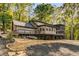 Beautiful home featuring a multi-tiered deck and stone accents, nestled among mature trees at 8316 Hewlett Rd, Sandy Springs, GA 30350