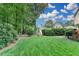 Beautifully landscaped backyard with mature trees and lush green grass at 10195 Brier Mill Ct, Alpharetta, GA 30022