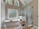 Bright bathroom with a soaking tub, glass shower, and white marble accents at 10195 Brier Mill Ct, Alpharetta, GA 30022