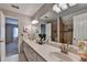 Bright bathroom with dual sinks, white countertop, decorative mirrors and lights, and a walk-in shower at 10195 Brier Mill Ct, Alpharetta, GA 30022
