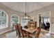 Well-lit dining room featuring hardwood floors, large windows, and decorative lighting at 10195 Brier Mill Ct, Alpharetta, GA 30022