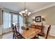 Cozy dining room featuring a chandelier, natural light, and traditional wood furniture at 10195 Brier Mill Ct, Alpharetta, GA 30022