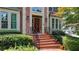 Inviting brick front porch with iron railings and potted plants leading to the entry door at 10195 Brier Mill Ct, Alpharetta, GA 30022
