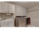 Well-equipped laundry room featuring a sink, storage cabinets, modern washer, and a dryer at 10195 Brier Mill Ct, Alpharetta, GA 30022