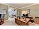 Well-lit office featuring a large desk, adjacent to the foyer with stairway access at 10195 Brier Mill Ct, Alpharetta, GA 30022