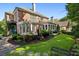 A spacious backyard featuring a brick house with a pergola, green lawn, and a stone pathway at 1382 Murrays Loch Nw Pl, Kennesaw, GA 30152