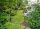 Picturesque backyard with manicured lawn, lush plantings, stone pathway, and outdoor seating area at 1382 Murrays Loch Nw Pl, Kennesaw, GA 30152