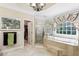 Luxurious bathroom with soaking tub, glass shower, and decorative window at 1382 Murrays Loch Nw Pl, Kennesaw, GA 30152