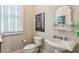 Charming bathroom featuring a pedestal sink, decorative mirror, and natural light at 1382 Murrays Loch Nw Pl, Kennesaw, GA 30152