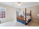 Bedroom with a four-poster bed, large window, and classic design at 1382 Murrays Loch Nw Pl, Kennesaw, GA 30152