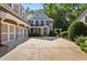 Elegant brick home with a spacious driveway, leading to a covered front porch and three-car garage at 1382 Murrays Loch Nw Pl, Kennesaw, GA 30152